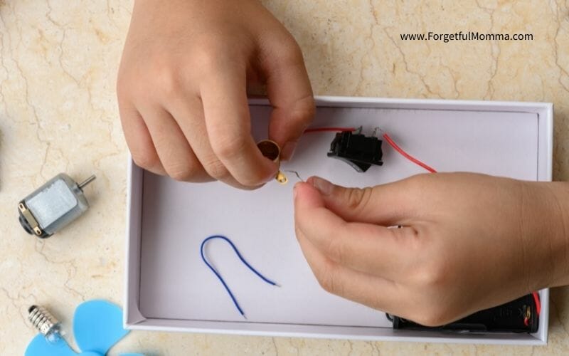 child's hands use circuits in white tray