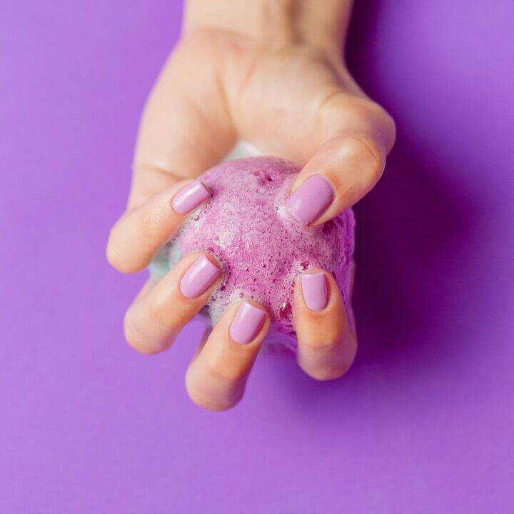 Epsom Salt Bath Bombs without citric acid in hand with a purple background