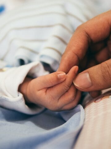 person holding baby's index finger