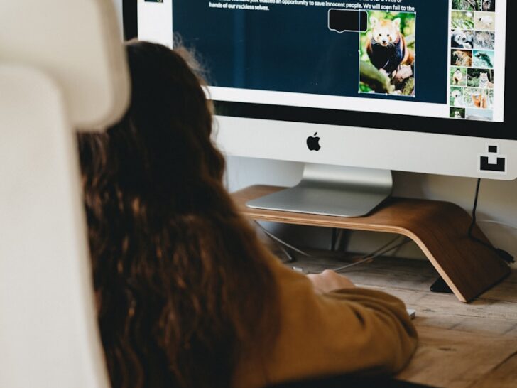 woman in black shirt sitting in front of silver imac