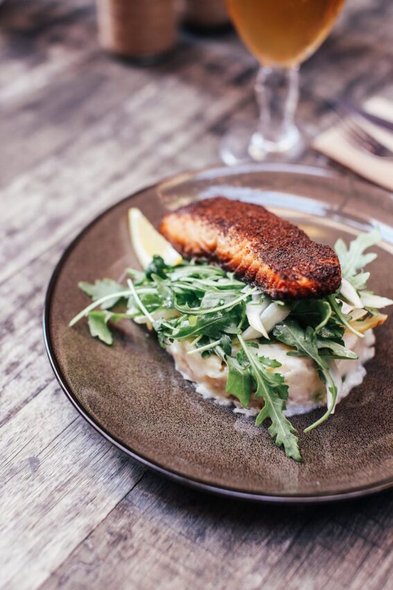 salmon served on creamy mashed potatoes with fresh arugula salad.