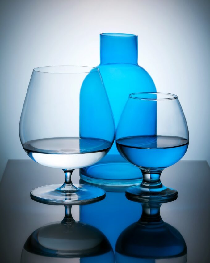 three glasses and a bottle on a table