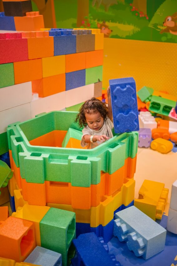 A child plays with large colorful building blocks.