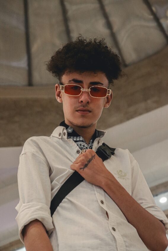 A young man wearing sunglasses and a bow tie