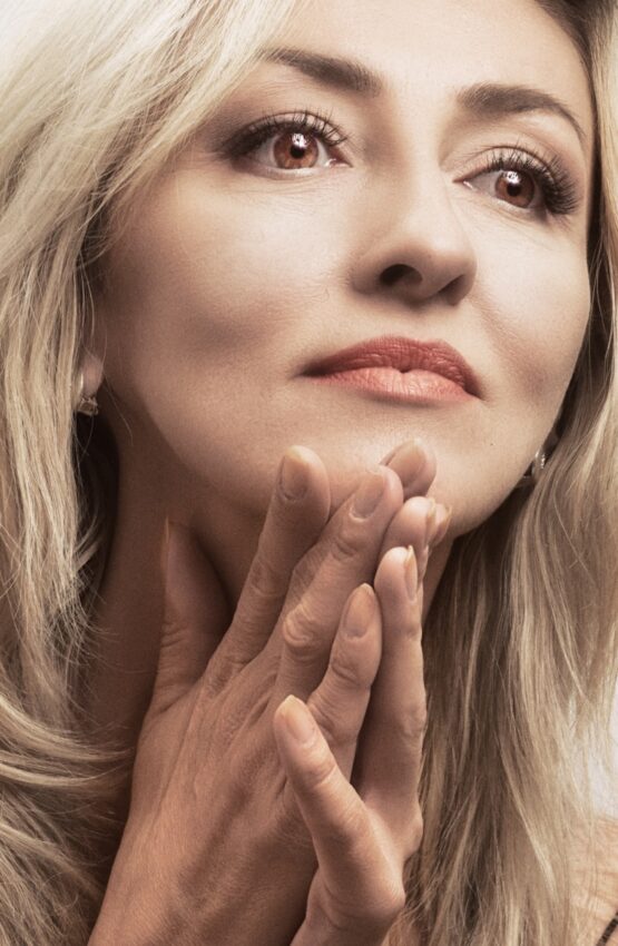 a close up of a person with a hand near her face