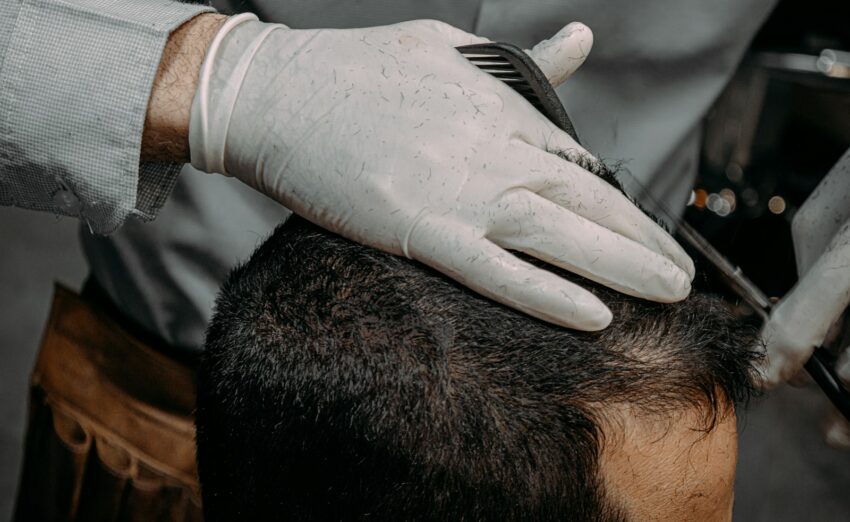 a close up of a person cutting another persons hair