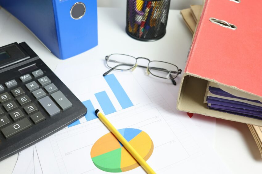 Desk with calculator, charts, and binders