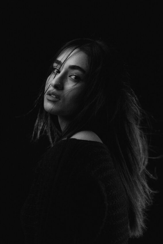 A woman with windswept hair looks over her shoulder